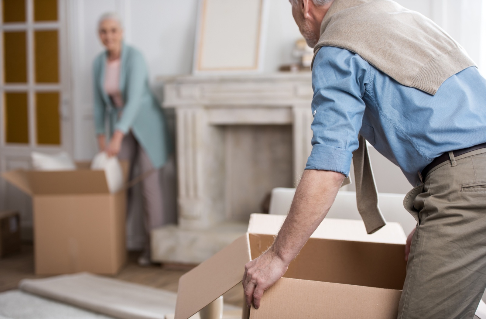 A senior couple pack up their living room together in preparation for moving to assisted living